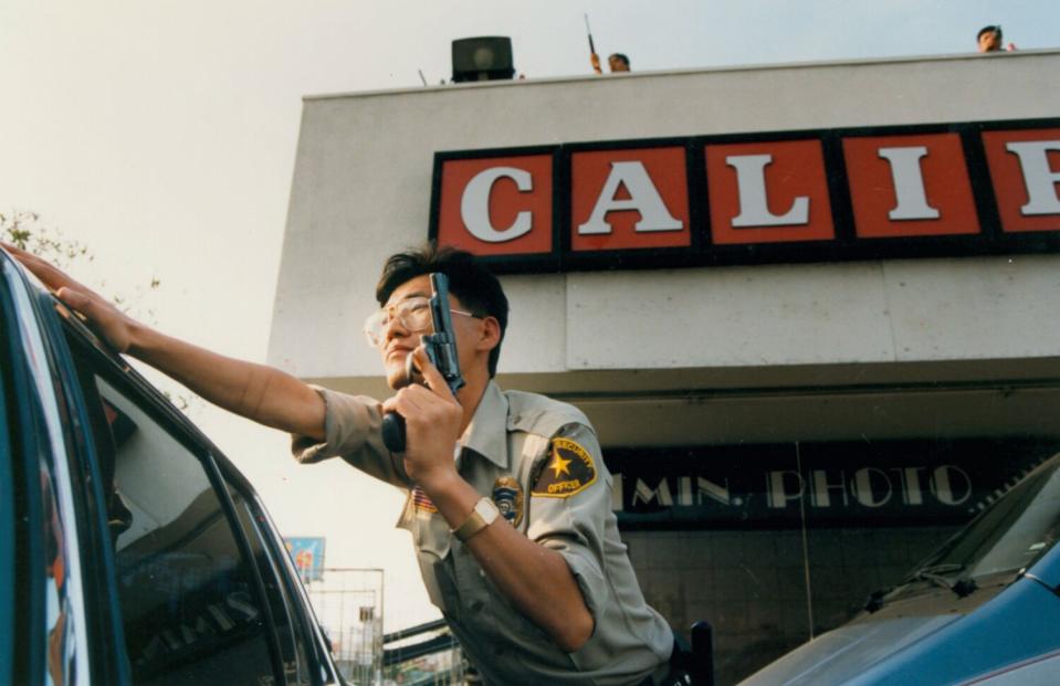 A security guard takes cover at the California Market in a mini mall at 5th Street and Western Avenue in Koreatown.