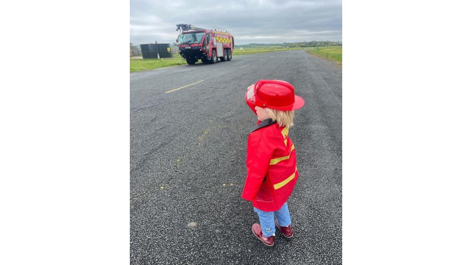 little boy wearing firefighter costume 