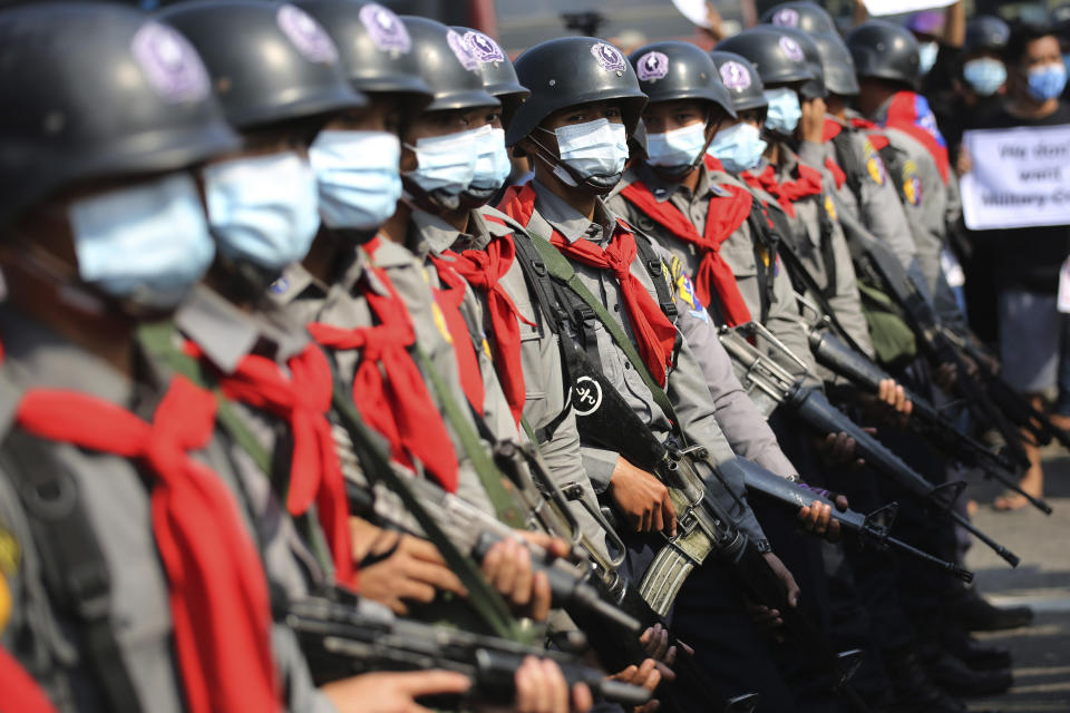 Armed riot police are seen near protesters in Naypyitaw, Myanmar on Monday, Feb. 8, 2021. Tension in the confrontations between the authorities and demonstrators against last week's coup in Myanmar boiled over Monday, as police fired a water cannon at peaceful protesters in the capital Naypyitaw. (AP Photo)