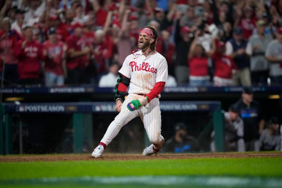 Philadelphia Phillies' Bryce Harper reacts after scoring during Game 1 in an NL wild-card baseball playoff series, Tuesday, Oct. 3, 2023, in Philadelphia. (AP Photo/Matt Slocum)