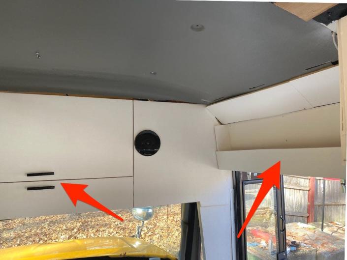 The couple added cabinets and a shelf to the front area of the bus.