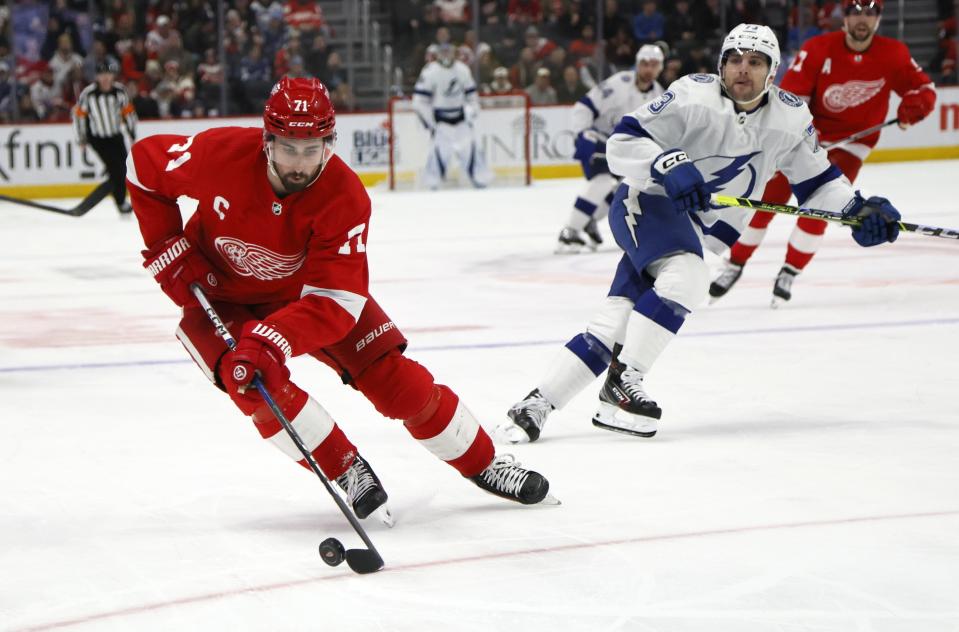 Detroit Red Wings center Dylan Larkin (71) moves the puck downice while being pursued by Tampa Bay Lightning left wing Conor Sheary (73) during the second period of an NHL hockey game Sunday, Jan. 21, 2024, in Detroit. (AP Photo/Duane Burleson)