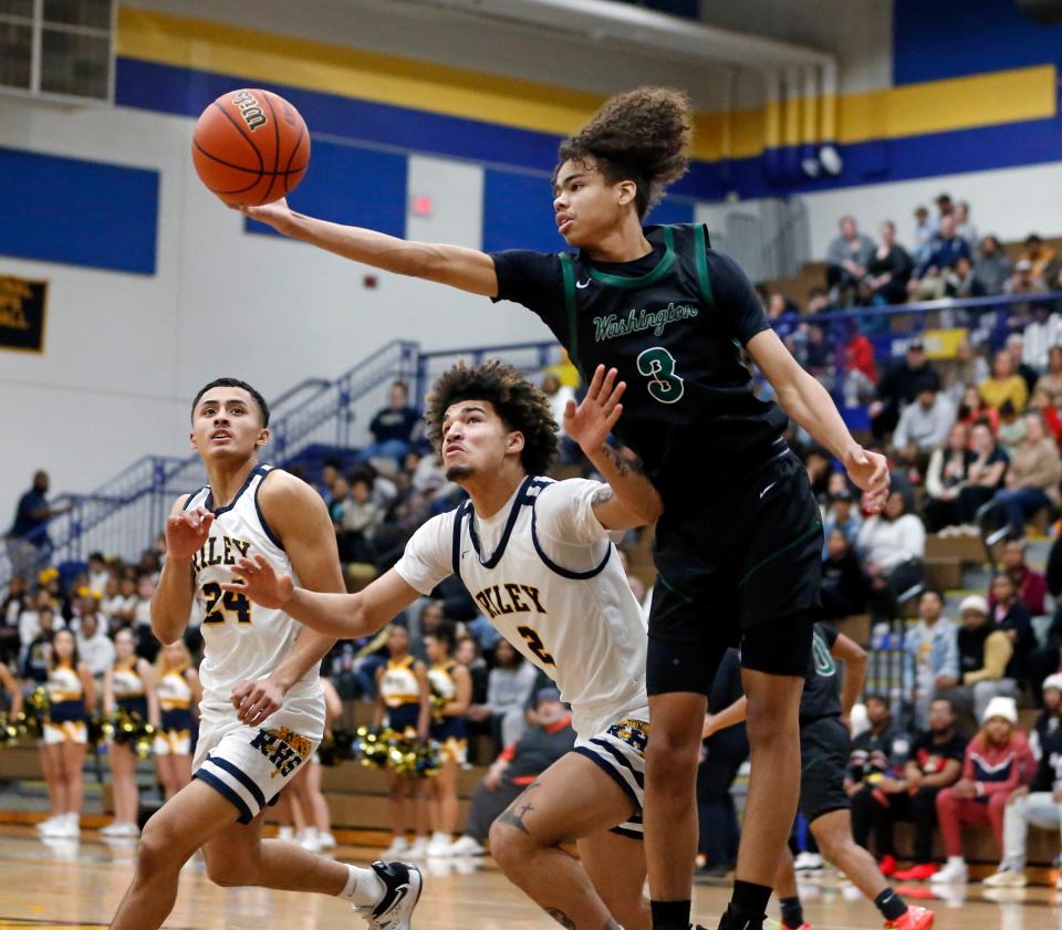 South Bend Washington sophomore Steven Reynolds III (3) grabs a rebound over South Bend Riley senior Ayden Kent during a boys basketball game Thursday, Feb. 1, 2024, at Riley High School.