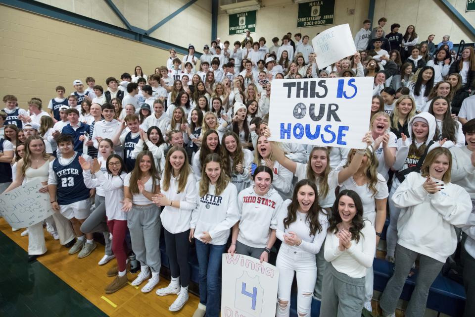 Members of the Exeter High School student section cheer on the Blue Hawks during Friday's Division I boys and girls basketball games against Winnacunnet.