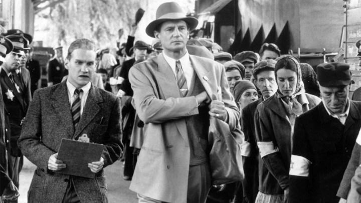 Liam Neeson as Oskar Schindler walking through a crowd in Schindler's List.