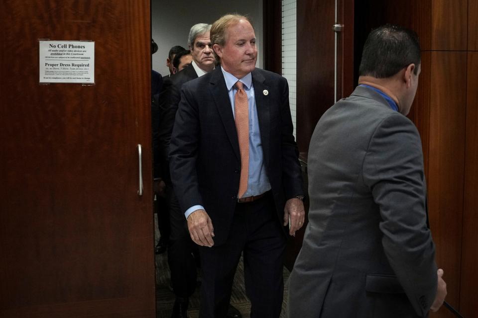 Attorney General Ken Paxton, center, leaves the 185th District Court after a hearing in his securities fraud case Feb. 16 at the Harris County criminal courthouse in Houston. A judge rejected Paxton’s attempts to throw out the charges, which have shadowed him for nearly a decade.