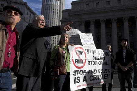 People hold signs protesting against the Stop-and-Frisk program, at a news conference outside the Federal Court in New York November 1, 2013. REUTERS/Andrew Kelly