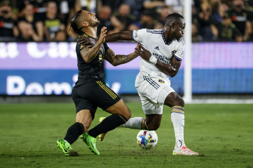 Los Angeles FC forward Cristian Arango, left, and LA Galaxy defender Sega Coulibaly vie for the ball during the first half of an MLS playoff soccer match Thursday, Oct. 20, 2022, in Los Angeles. (AP Photo/Ringo H.W. Chiu)