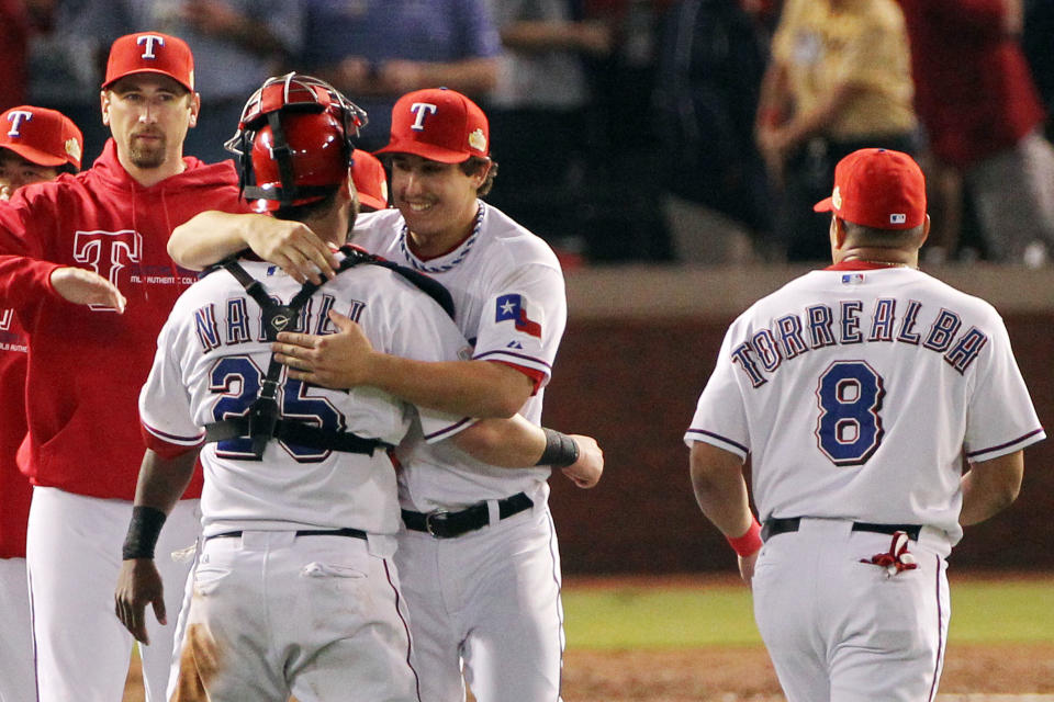 ARLINGTON, TX - OCTOBER 23: Derek Holland #45 and Mike Napoli #25 of the Texas Rangers celebrate after defeating the St. Louis Cardinals 4-0 in Game Four of the MLB World Series at Rangers Ballpark in Arlington on October 23, 2011 in Arlington, Texas. (Photo by Ezra Shaw/Getty Images)