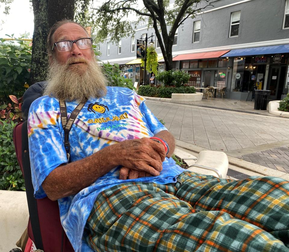 Thomas Williams reclines on a bicycle and people-watches on Clematis Street following the threat of a tropical storm over South Florida Saturday.