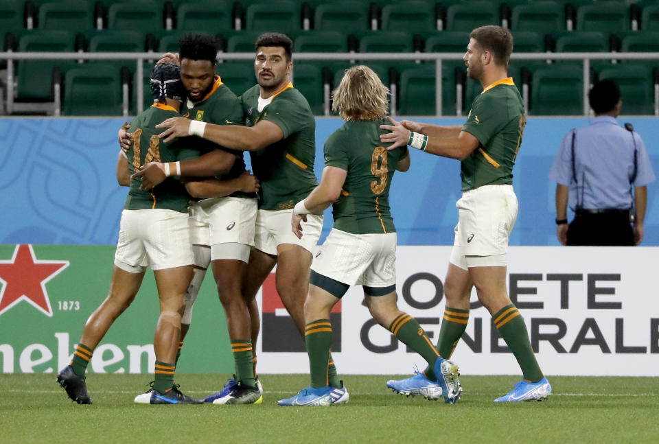 South Africa's Cheslin Kolbe, left, is congratulated by his teammates after scoring a try during the Rugby World Cup Pool B game at Shizuoka Stadium Ecopa between South Africa and Italy, in Shizuoka, Japan, Friday, Oct. 4, 2019. (AP Photo/Shuji Kajiyama)