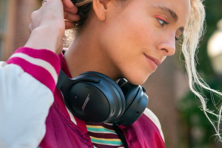 A woman wearing the Bose QuietComfort 45 around her neck.