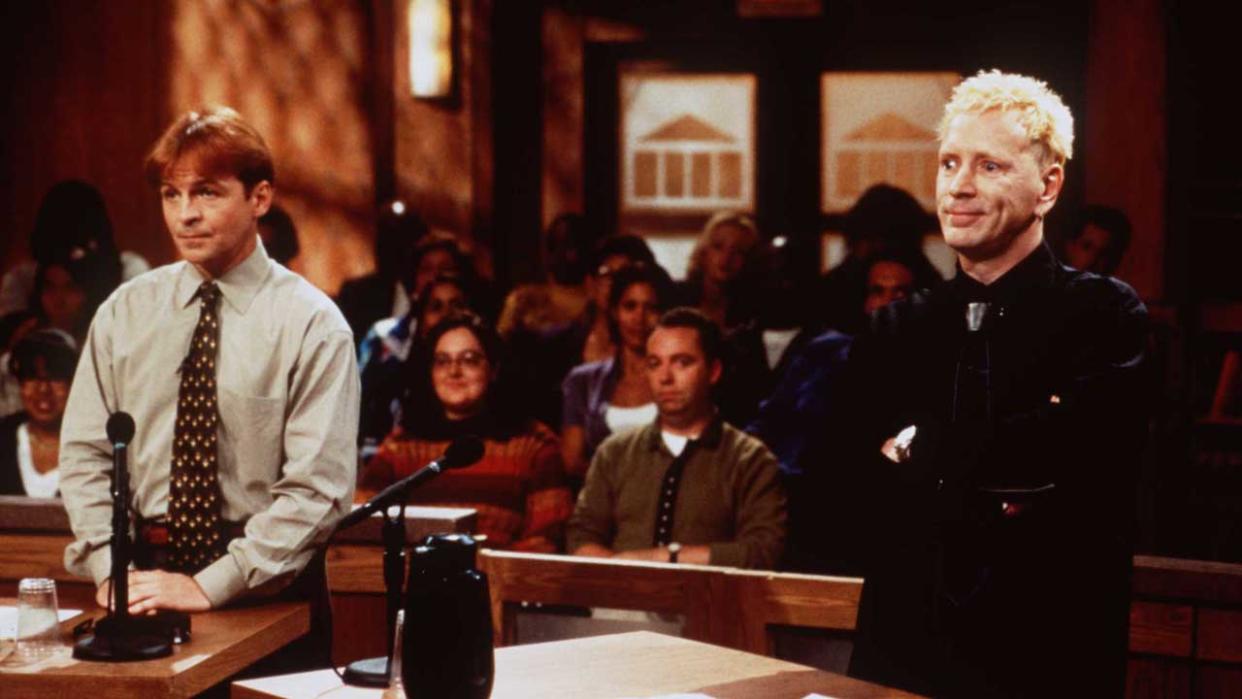  Robert Williams and John Lydon facing Judge Judy in the courtroom. 