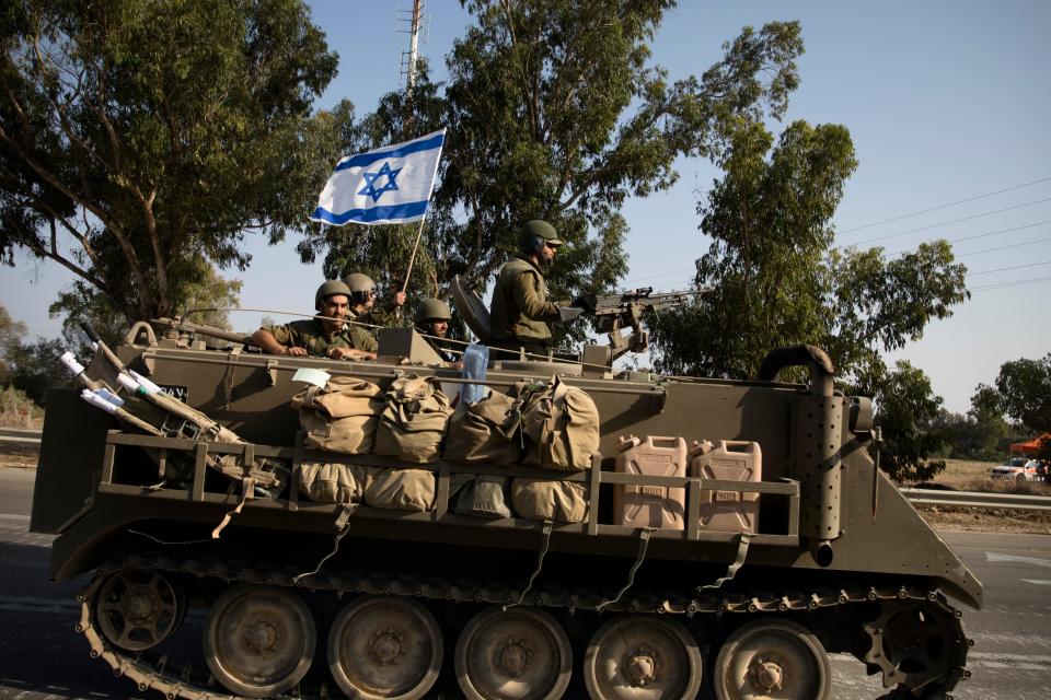 Israeli soldiers in an armoured personnel carrier head towards the southern border with the Gaza Strip on October 8, 2023 in Sderot, Israel.