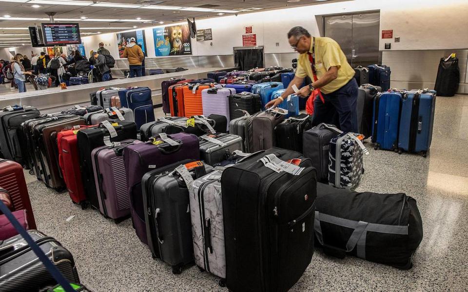 In this file photo from Dec. 27, 2022, Enrique Borregales sorted through luggage piling up at Miami International Airport as many flights had been canceled due to bad winter weather across the U.S.