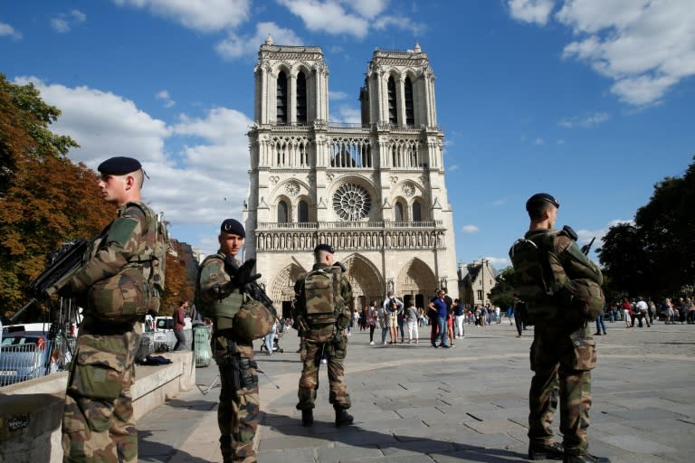 French soldiers of the Sentinel Operation stand alert outside The Notre Dame de Paris cathedral in Paris on August 20, 2017, ahead of a mass dedicated to the victims of recent terror attacks and natural disasters across the world