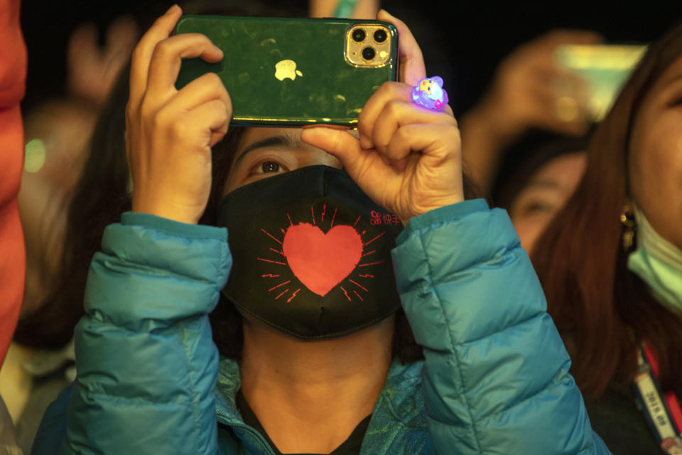 A woman wearing a mask with a heart shape attends the Hello Chongli-Thaiwoo Midi Music Season held in Chongli in northern China's Hebei Province on Saturday, Aug. 15, 2020. Large scale events are returning with China having contained the coronavirus outbreak with majority of new cases being in travelers arriving from overseas. (AP Photo/Ng Han Guan)