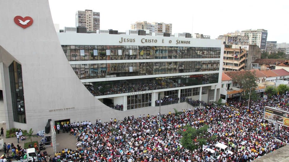 Edificio de la Iglesia Universal en Maputo rodeado de cientos de fieles