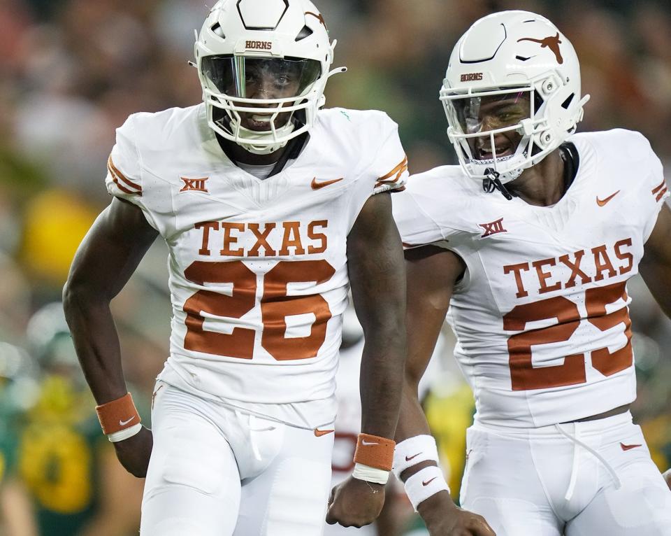 Texas running back Quintrevion Wisner (26) and Texas defensive back Jelani McDonald (25) celebrates a big tackle on the kick return in the third quarter of an NCAA college football game, Saturday, Sept. 23, 2023, in Waco, <a class="link " href="https://sports.yahoo.com/ncaaf/teams/texas/" data-i13n="sec:content-canvas;subsec:anchor_text;elm:context_link" data-ylk="slk:Texas;sec:content-canvas;subsec:anchor_text;elm:context_link;itc:0">Texas</a>.