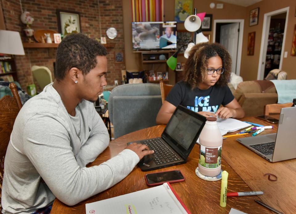 Ty Jackson (left), 18, studies with his sister Ellie, 15, at their home during the coronavirus pandemic Thursday, April 16, 2020 in Jacksonville, Florida. They have been participating in online learning since their schools have been closed due to the virus.