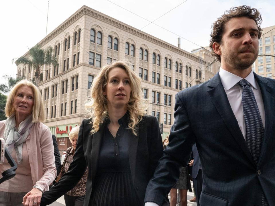 Elizabeth Holmes (C), founder and former CEO of blood testing and life sciences company Theranos, walks with her mother Noel Holmes and partner Billy Evans into the federal courthouse for her sentencing hearing on November 18, 2022 in San Jose, California (AFP via Getty Images)