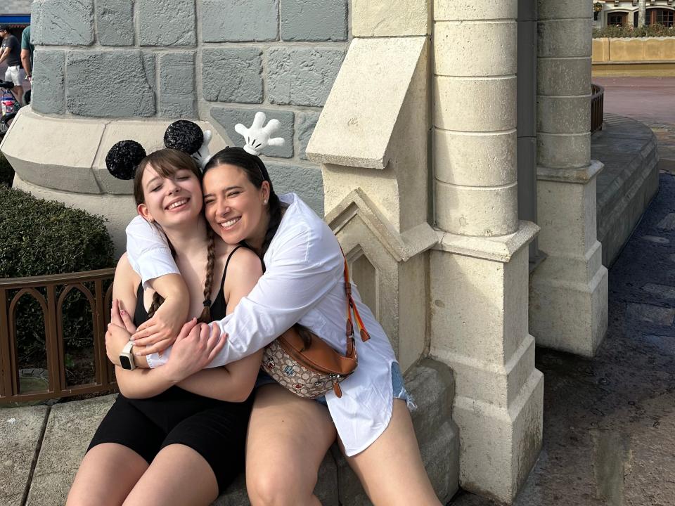 josie hugging someone while taking a photo in magic kingdom at disney world