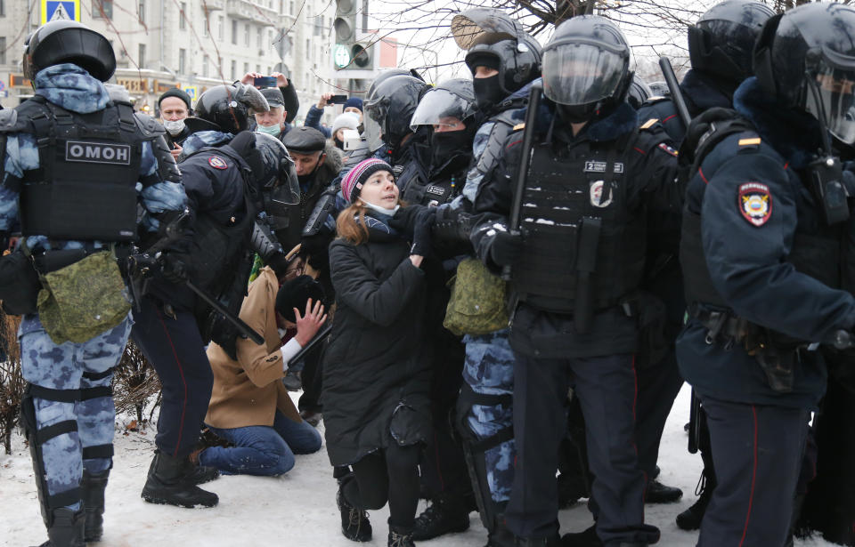 FILE - In this Jan. 23, 2021, file photo, police detain a man as another policeman stops a young woman, center, during a protest against the jailing of opposition leader Alexei Navalny in Moscow, Russia. Allies of Navalny are calling for new protests next weekend to demand his release, following a wave of demonstrations across the country that brought out tens of thousands in a defiant challenge to President Vladimir Putin. (AP Photo/Alexander Zemlianichenko, File)