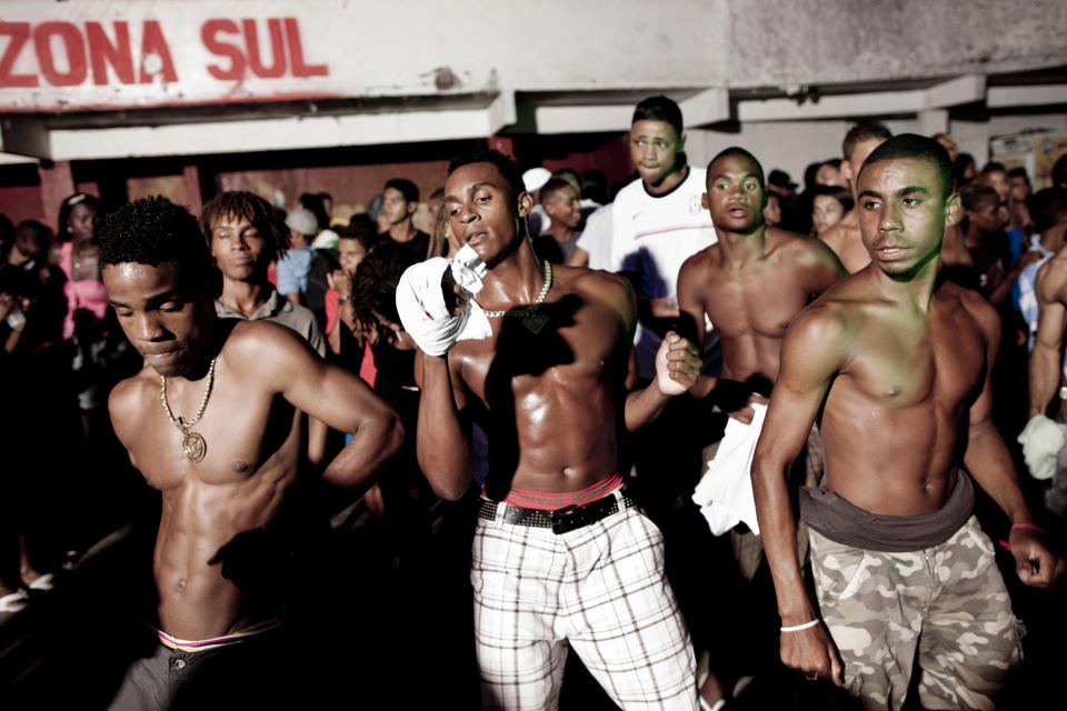 In this Feb. 3, 2012 photo, people dance at a funk "baile" in the Cantagalo slum in Rio de Janeiro, Brazil. In the last five years, the genre has expanded its reach and enjoyed more social acceptance, with the help of an association of funk artists and supporters, Apafunk, and the backing of liberal legislators. Its market potential has become hard to ignore: A recent survey by the Brazilian think tank the Getulio Vargas Foundation found funk disc jockeys, MCs and others generate about $720 million a month in revenue. (AP Photo/Felipe Dana)