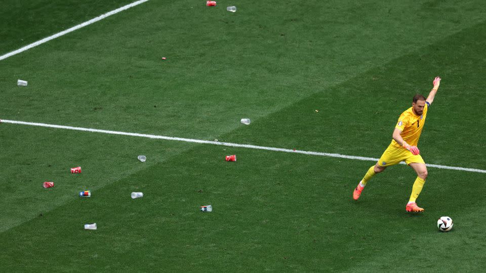 Slovenia goalkeeper Jan Oblak takes a freekick during a game against Serbia at Euro 2024 with beer cups around him. - Carl Recine/Getty Images