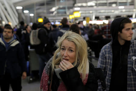 A woman reacts in the departures area of Terminal 4 at John F. Kennedy International Airport following a series of flight cancellations and delays, and a water main break in the arrivals area in New York City, U.S. January 7, 2018. REUTERS/Andrew Kelly