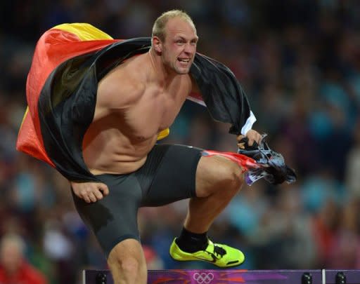 Germany's Robert Harting celebrates after winning the men's discus throw final at the athletics event during the London 2012 Olympic Games in London