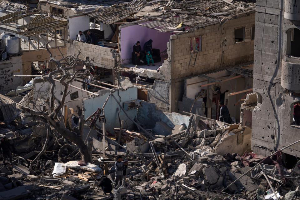 Palestinians look at the destruction after an Israeli strike on residential buildings and a mosque in Rafah (AP)