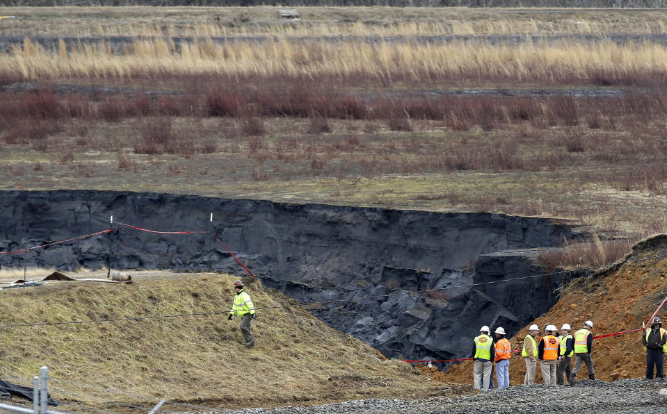 FILE - In a Wednesday, Feb. 5, 2014 file photo, Duke Energy engineers and contractors survey the site of a coal ash spill at the Dan River Power Plant in Eden, N.C. The federal, North Carolina and Virginia governments want a judge to declare Charlotte-based Duke Energy liable for environmental damage from a leak five years ago that left miles of a river shared by the two states coated in hazardous coal ash. Government lawyers on Thursday, July 18, 2019 sought to have Duke Energy declared responsible for harming fish, birds, amphibians and the bottom of the Dan River. (AP Photo/Gerry Broome, File)