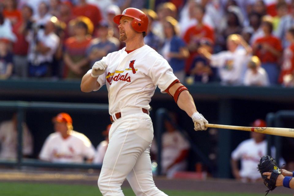 Mark McGwire watches homer number 67 clear the fence against Montreal on Sept. 26, 1998 to reclaim the season record from Chicago's Sammy Sosa.