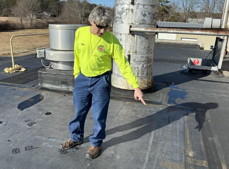 Superintendent Nick Rico points out details related to the new roof over the electrical room at the Wells Sanitary District's treatment plant in Wells, Maine, on March 7, 2024. The roof caught fire in January 2023.