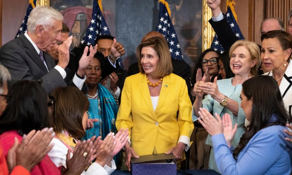 Democrats applaud after Nancy Pelosi signs the Inflation Reduction Act, which includes climate protections, among other measures.