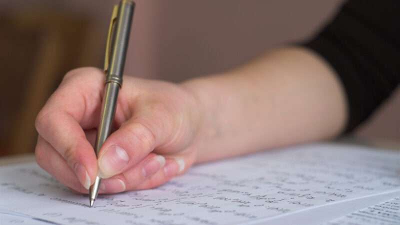 Close-up of a student's hand taking a test.