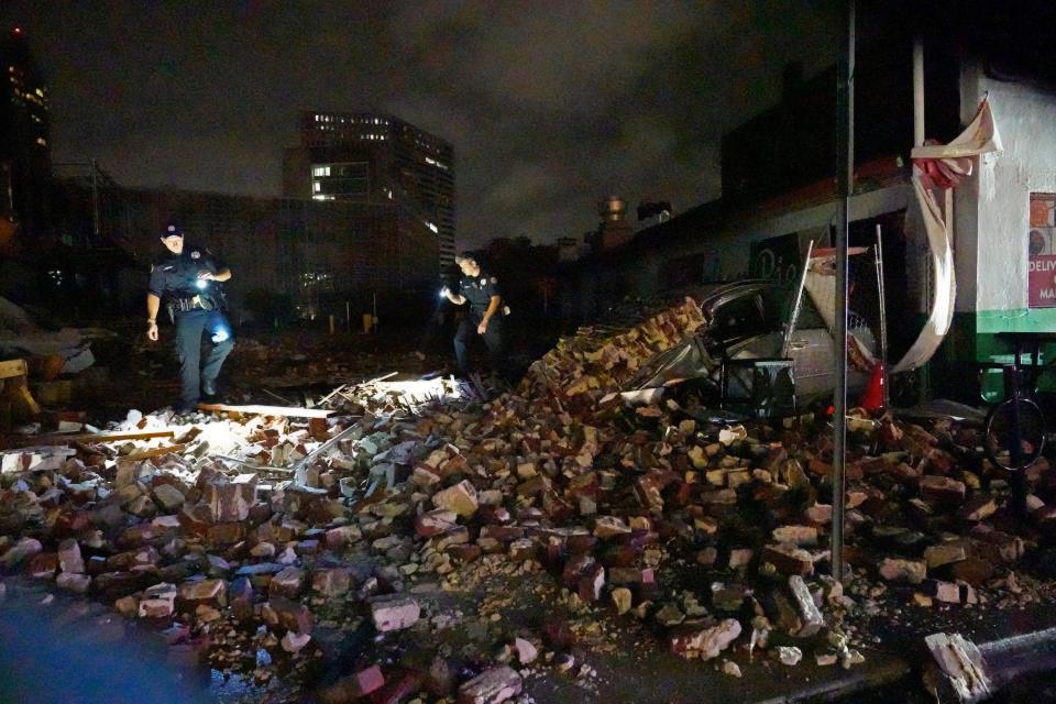 New Orleans Police detectives look over debris from a building that collapsed (AP Photo/Gerald Herbert)