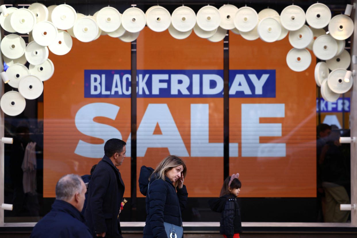 People walk past Black Friday signage in a shop window during Black Friday on Regent Street in London, Britain, November 25, 2022. REUTERS/Henry Nicholls