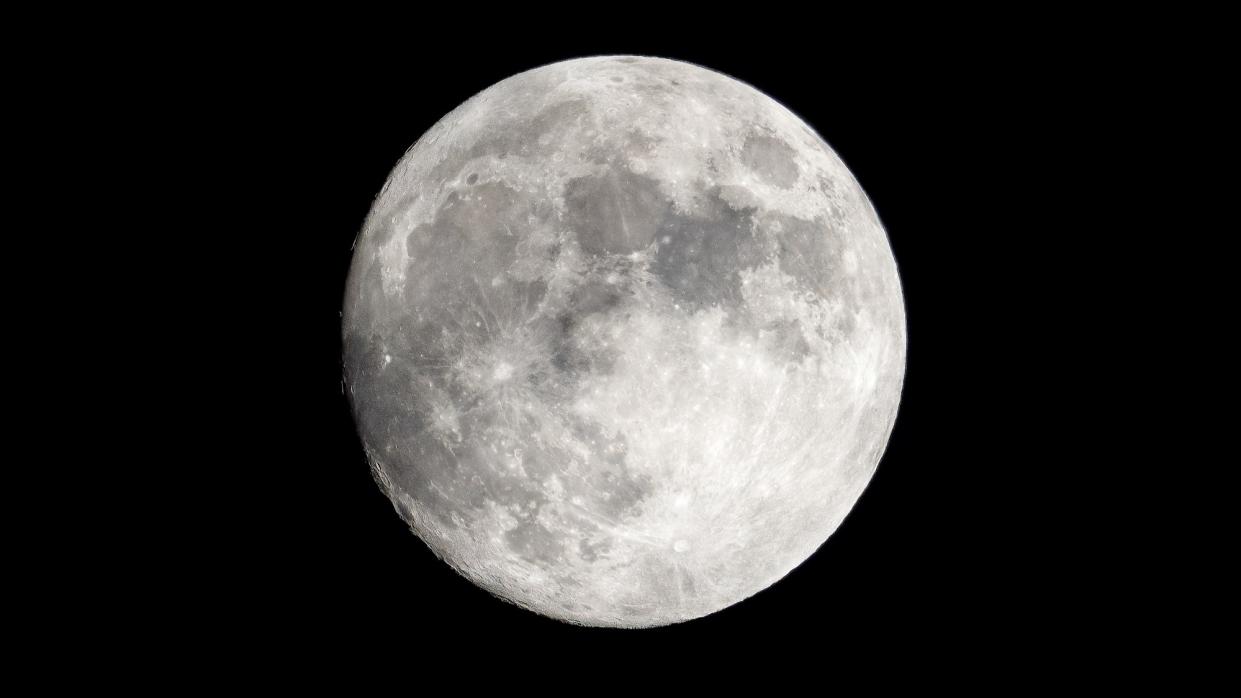  November full moon shining brightly against a black background. 