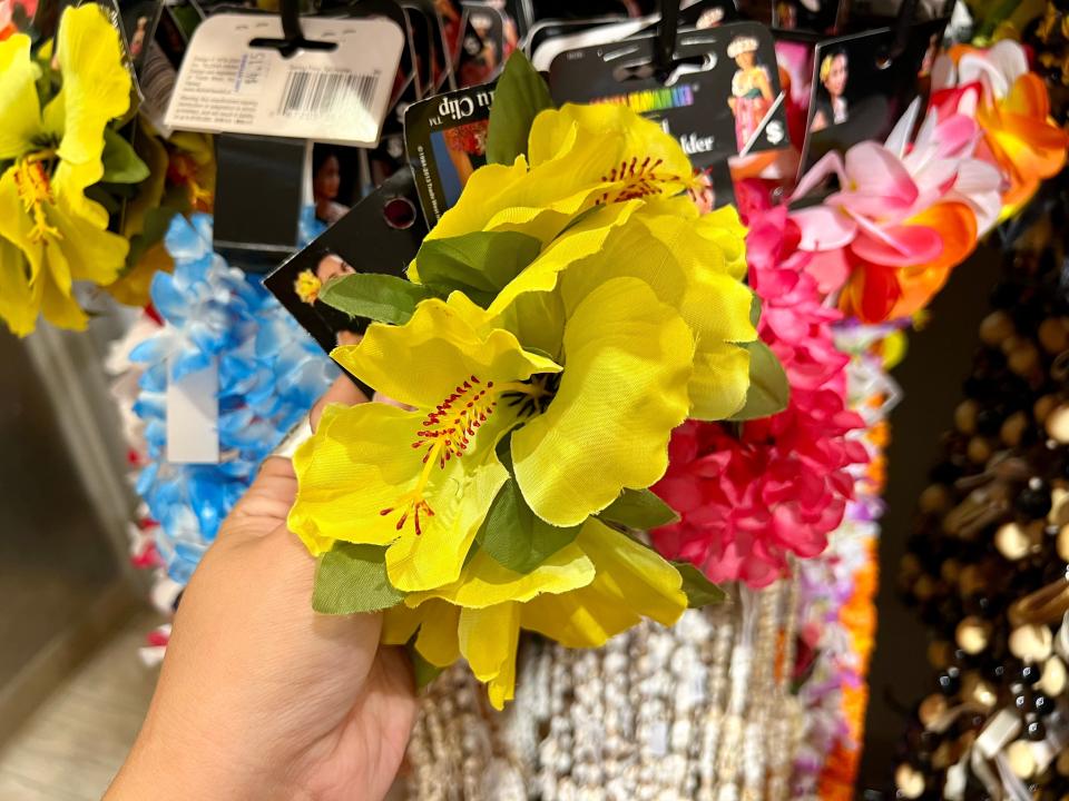 The writer holds a fake yellow flower that's part of a lei
