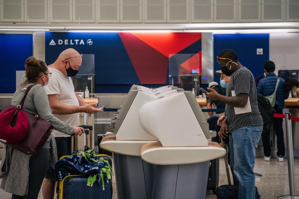 People check in at a Delta station for departing flights at the George Bush Intercontinental Airport on Jan. 13 in Houston.