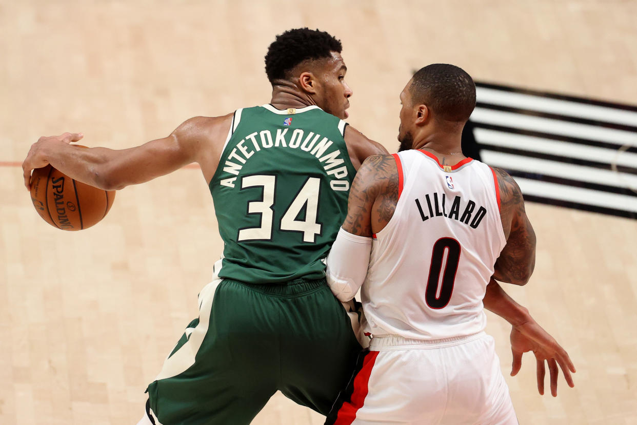 PORTLAND, OREGON - APRIL 02: Giannis Antetokounmpo #34 of the Milwaukee Bucks dribbles against Damian Lillard #0 of the Portland Trail Blazers in the third quarter at Moda Center on April 02, 2021 in Portland, Oregon. NOTE TO USER: User expressly acknowledges and agrees that, by downloading and or using this photograph, User is consenting to the terms and conditions of the Getty Images License Agreement.  (Photo by Abbie Parr/Getty Images)