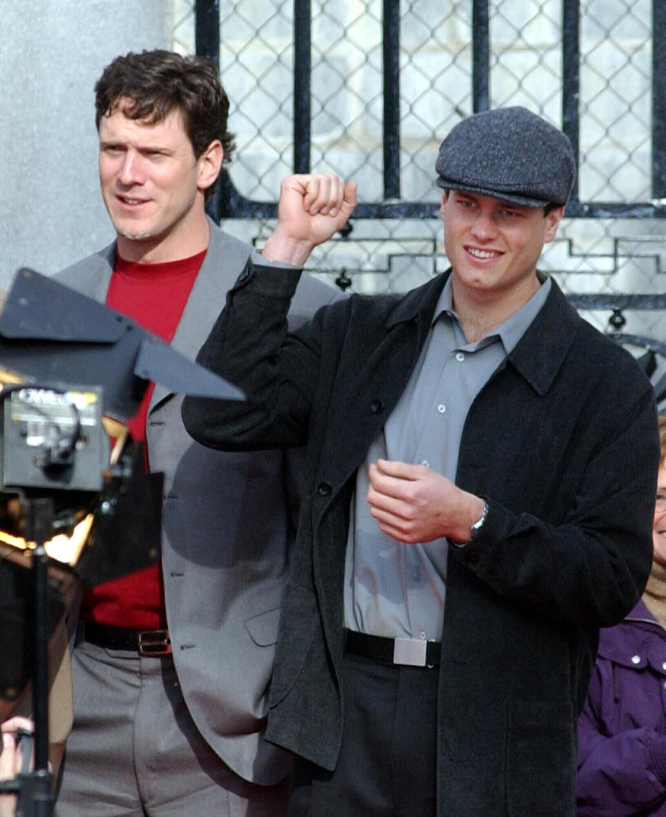 FILE - New England Patriots quarterbacks Drew Bledsoe, left, and Tom Brady, right, cheer with the crowd at a pep rally held at the Statehouse in Boston, Monday, Jan. 28, 2002, before the Patriots go to New Orleans to play in the Super Bowl next Sunday. Tom Brady has retired after winning seven Super Bowls and setting numerous passing records in an unprecedented 22-year-career. He made the announcement, Tuesday, Feb. 1, 2022, in a long post on Instagram. (AP Photo/Olivia Hanley, File)