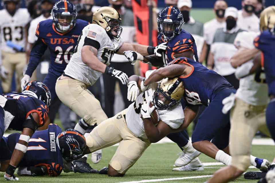 Army's Jakobi Buchanan, center, is brought down by UTSA's Jamal Ligon (88) during an NCAA college football game on Saturday, Oct. 17, 2020, in San Antonio, Texas. (AP Photo/Darren Abate)