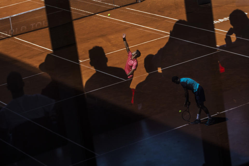 <p>Spain’s Fernando Verdasco, in red, serves during a Madrid Open tennis match against Croatia’s Marin Čilić, as Grigor Dimitrov from Bulgaria, in blue and reflected in the glass, prepares to serve to Fabio Fognini from Italy in the adjacent court, in Madrid, May 6, 2015. (AP Photo/Andres Kudacki) </p>