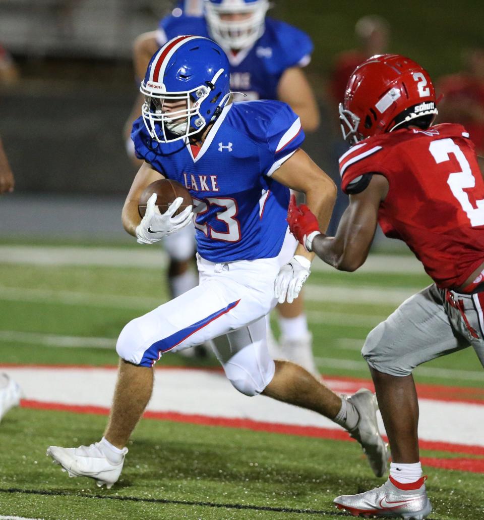 Lake's Ty Miller runs by an Akron East defender during a Sept. 3, 2021 high school football game at Lake.