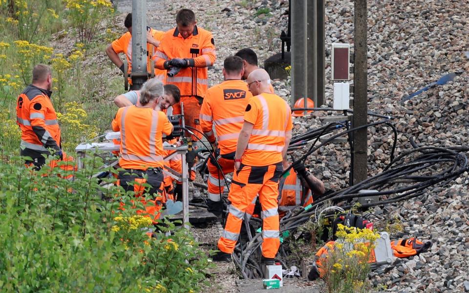 SNCF employees inspect the scene of a suspected attack on the high speed railway network at Croiselles,