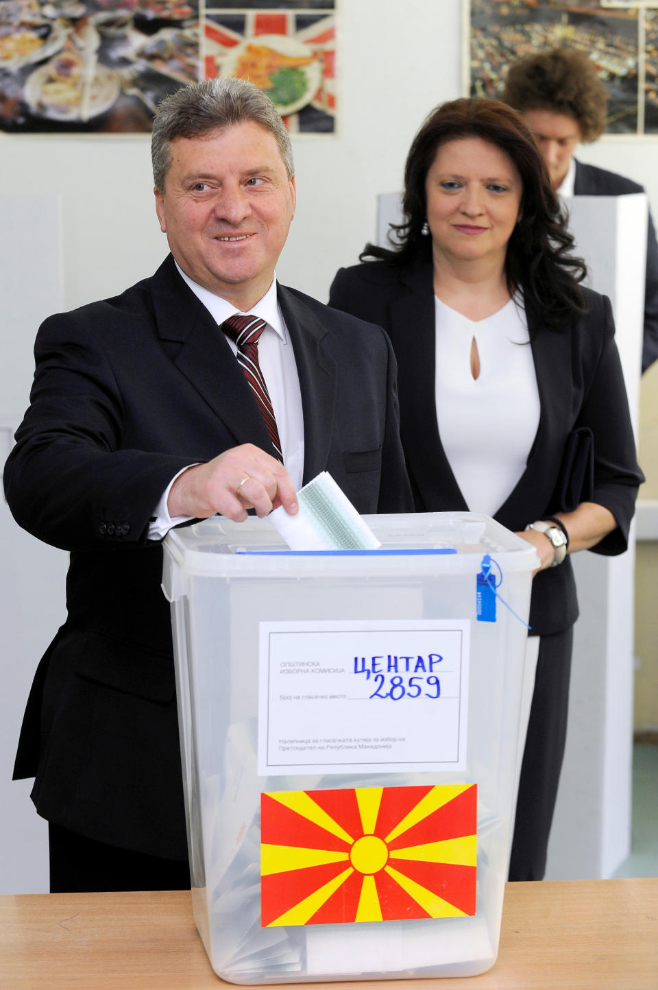 Seeking his second term, Gjorge Ivanov, left, the current Macedonian President and a candidate of the ruling conservative VMRO-DPMNE party, accompanied by his wife Maja Ivanova, right, casts his ballot for the presidential elections in Skopje, Macedonia, on Sunday, April 13, 2014. Macedonia votes on the fifth presidential elections since the country's independence. (AP Photo/Boris Grdanoski)