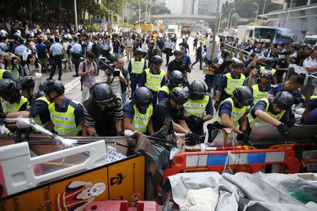 Police remove a barricade at a protest site in Admiralty near the government headquarters in Hong Kong October 14, 2014. REUTERS/Carlos Barria
